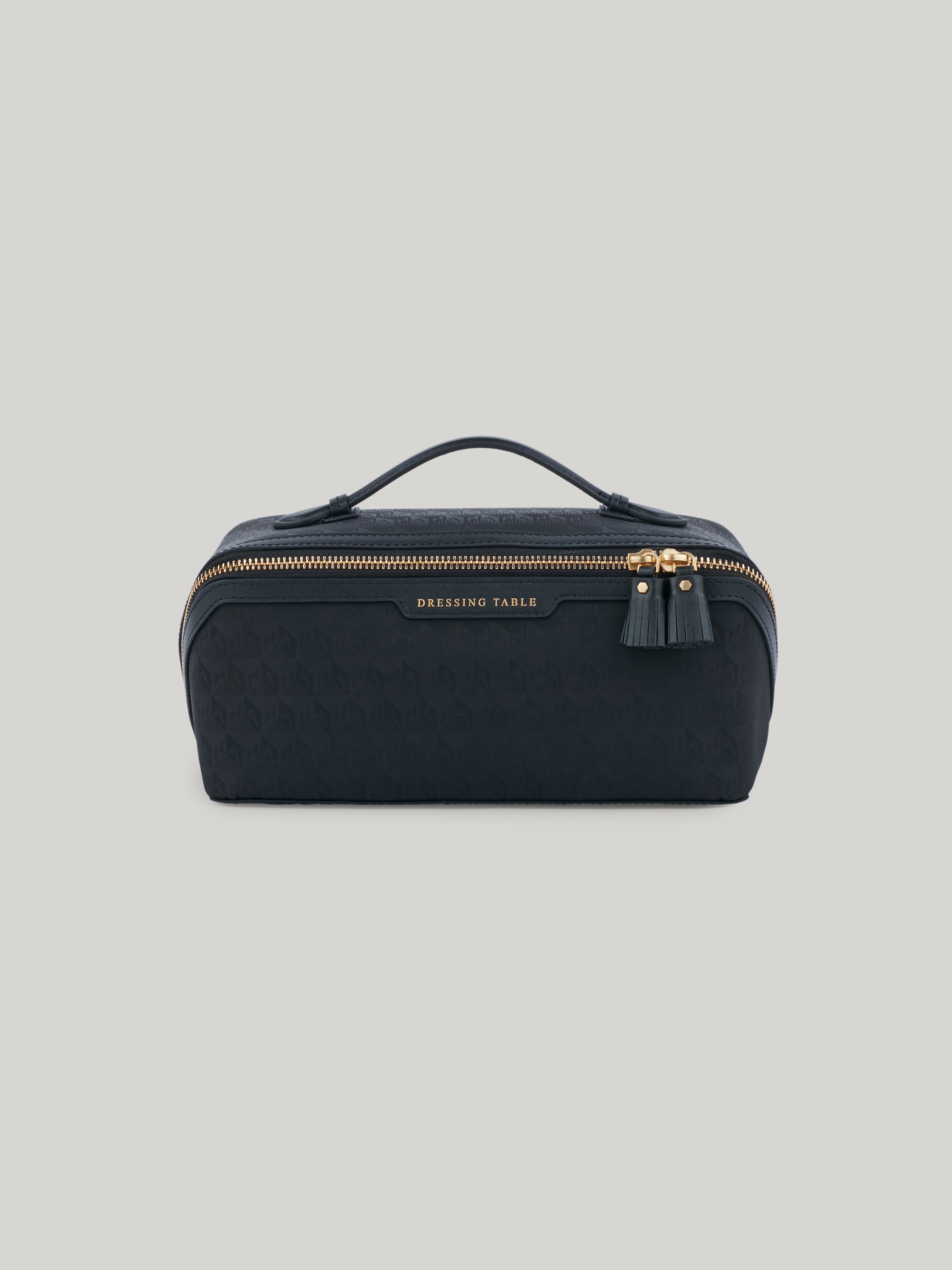 The epitome of functionality, the Anya Hindmarch Dressing Table opens up to lay flat, revealing a world of effortless organisation. With a central zip pocket and elasticated side pockets, there is a designated home for all of your beauty essentials. The easy-carry handle makes it your travel companion, bringing elegance and convenience wherever you go.