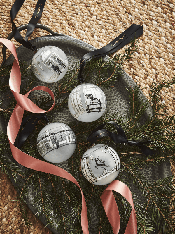 ﻿Deck the halls and dress the tree with the art deco style of Claridge’s. Using a time-honoured ‘inside out’ painting technique, this hand-blown glass bauble depicts the duo of ladies that always make an entrance at Claridge’s, famously featuring on the doors to the Foyer & Reading Room.