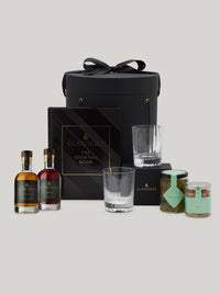 A gift set including various bottles of alcohol, mixers, and glassware, presented in a black box with 'Claridge's' cocktail book, intended for cocktail preparation.