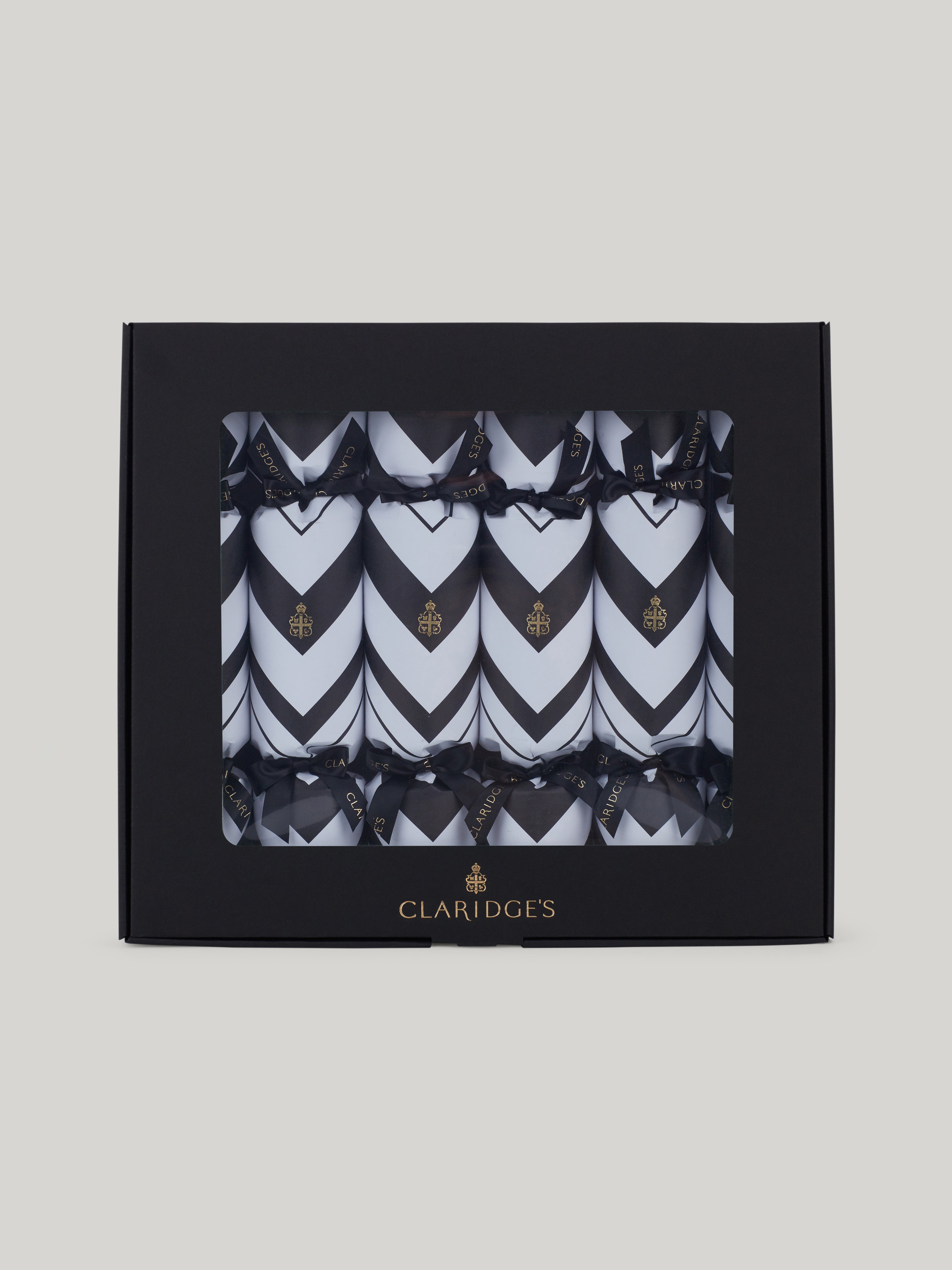 Claridge's Christmas crackers are handmade in England, Presented in a black box with 6 crackers, each one in the hotel's iconic black and white chevron design